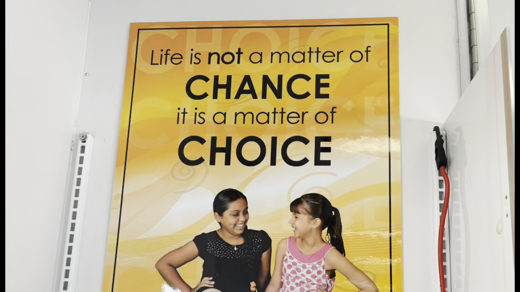 A large, inspirational poster features two girls on an orange and yellow background. The text reads: "Life is not a matter of CHANCE it is a matter of CHOICE."